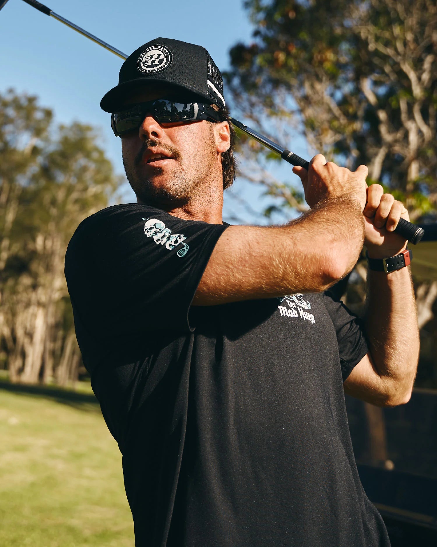 THE MAD HUEYS HITTIN FK ALL SS GOLF POLO – BLACK